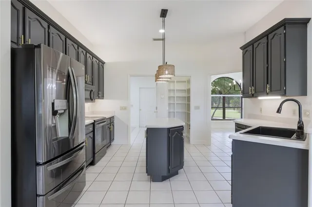 a kitchen with granite countertop a refrigerator and a sink