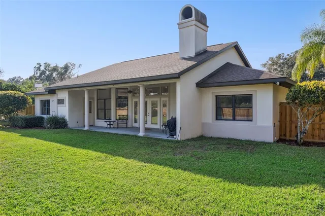 a view of a patio with chairs and table in a yard