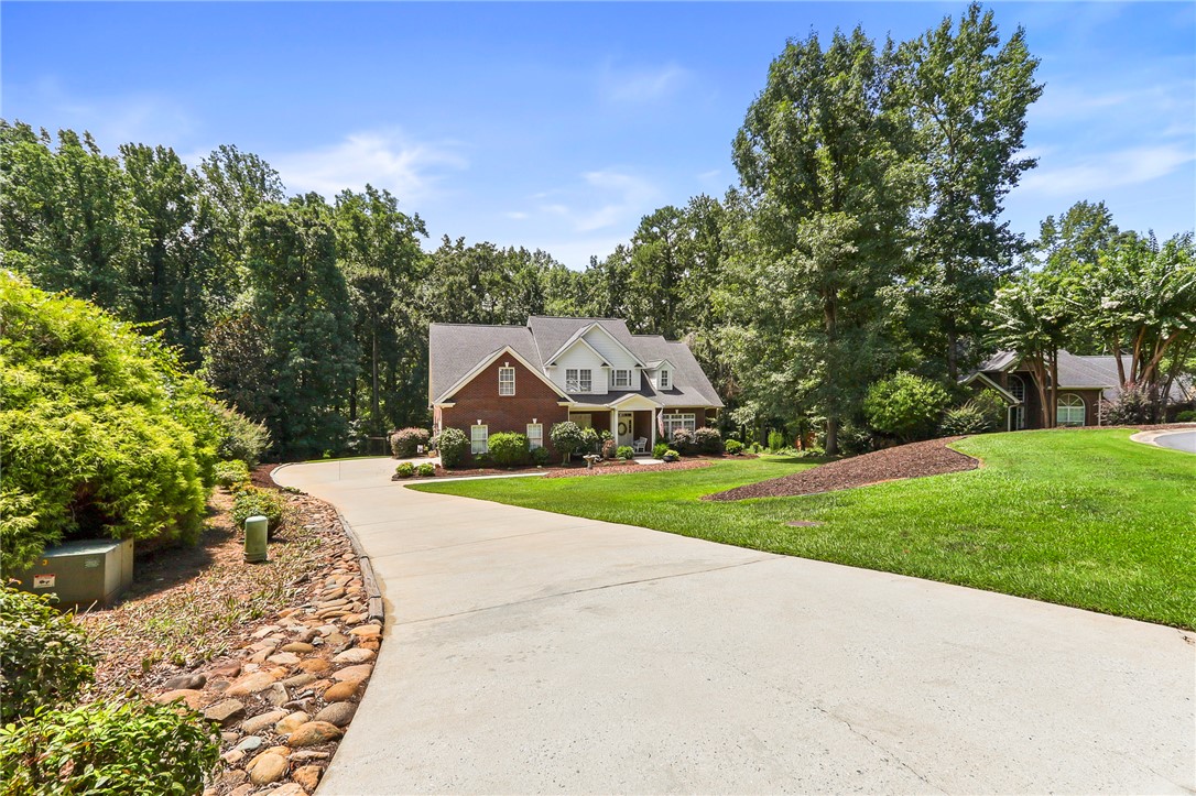 103 C-10-147D Anderson, SC 29621 - Photo 2 of 49 A graceful residence unfolds behind a curving driveway, framed by verdant landscaping and mature trees.