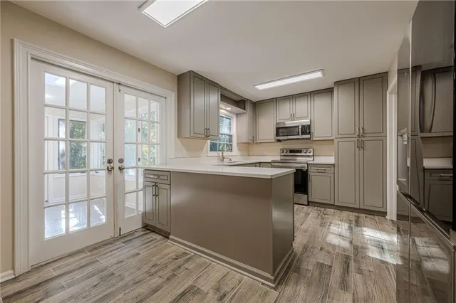 a kitchen with granite countertop a refrigerator stove top oven and sink