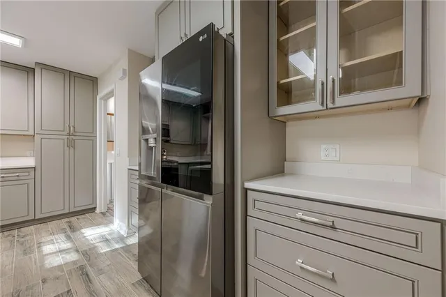 a kitchen view with a refrigerator and cabinets