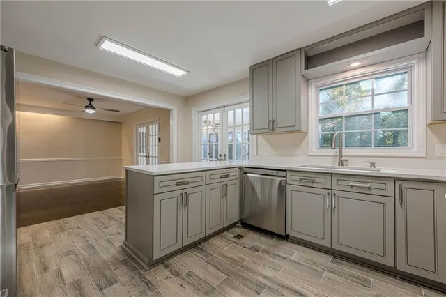 a kitchen with granite countertop cabinets stainless steel appliances a sink and a large window