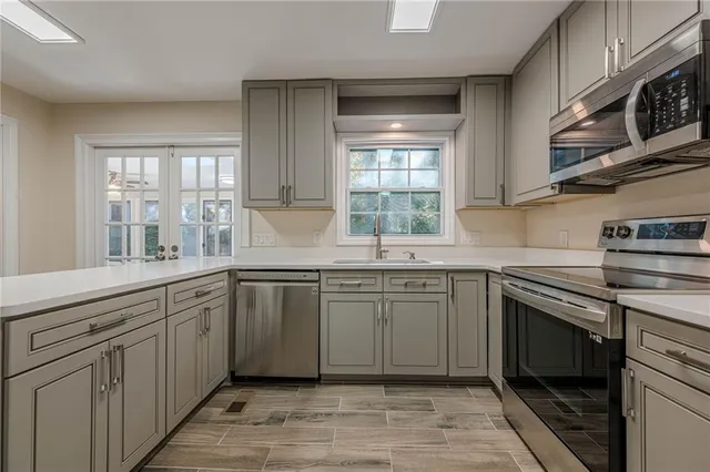 a kitchen with granite countertop cabinets stainless steel appliances a sink and window