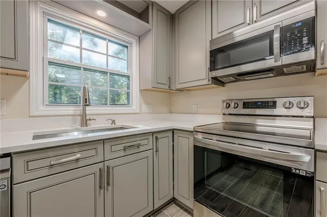 a kitchen with a sink stove and microwave