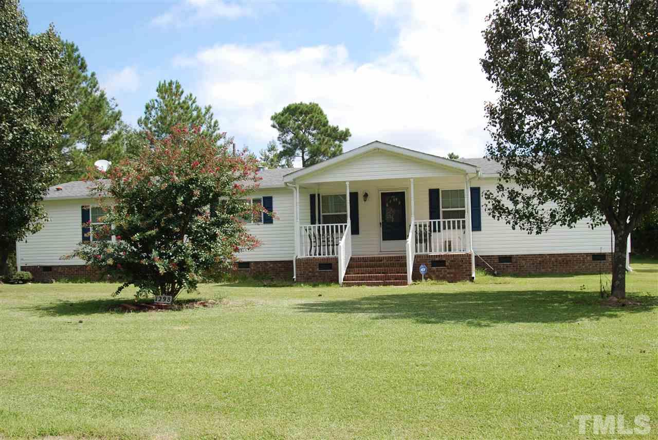 1298 O B J Road Dunn, NC 28334 - Photo 1 of 24 a big white house with a big yard and large trees