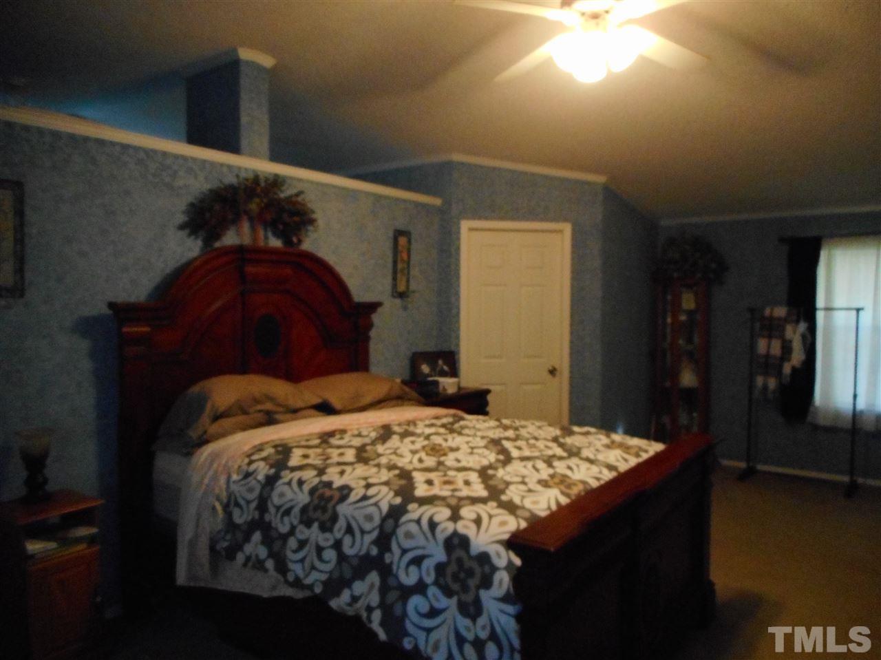 1298 O B J Road Dunn, NC 28334 - Photo 14 of 24 a bed sitting in a bedroom next to a window