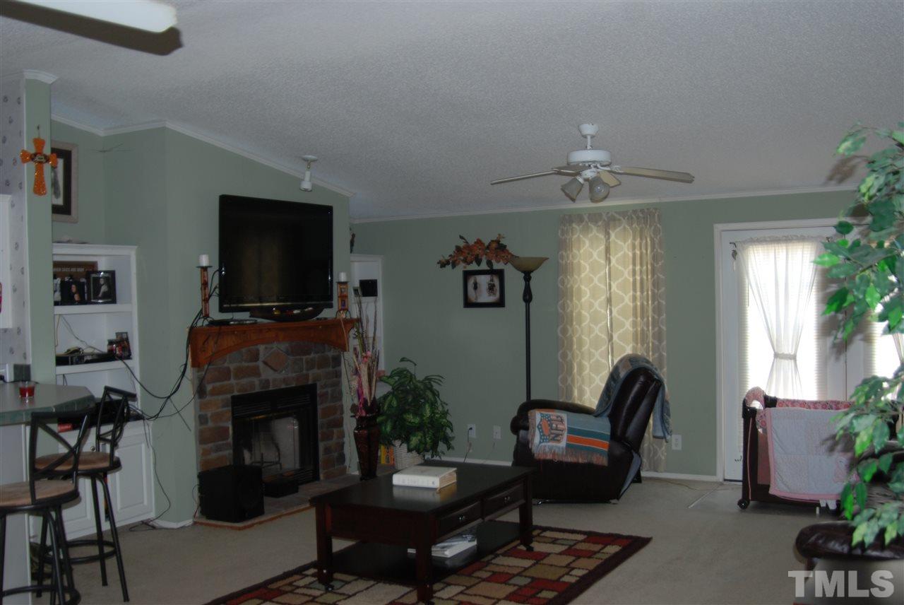 1298 O B J Road Dunn, NC 28334 - Photo 8 of 24 a living room with furniture a flat screen tv and a fireplace