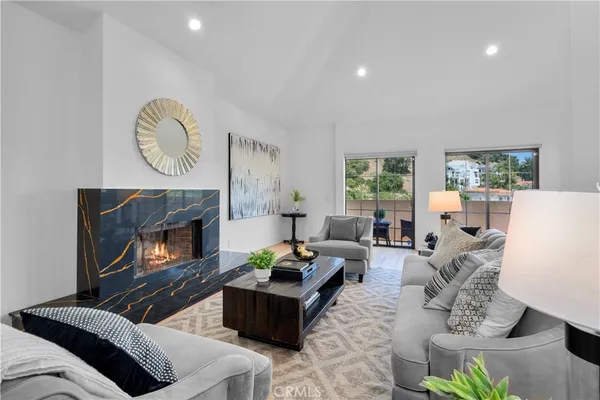 a living room with furniture a fireplace and a large window