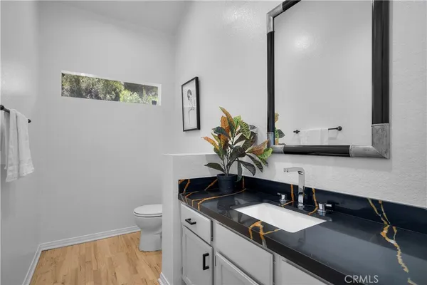a bathroom with a granite countertop toilet sink and mirror
