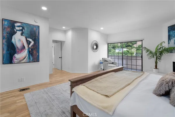 a bedroom with a bed and a painting on the wall