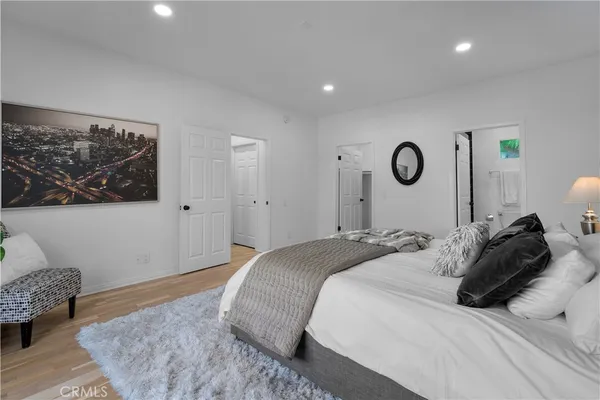a bedroom with a bed and painting on the wall