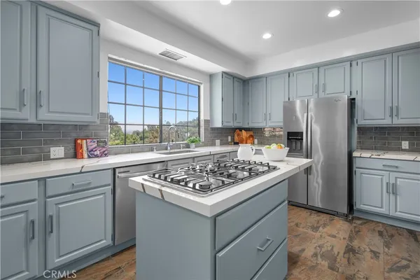 a kitchen with white cabinets and appliances