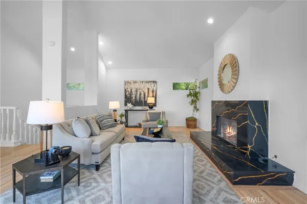 a living room with furniture a fireplace and a lamp