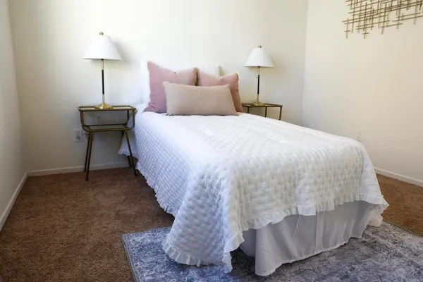 a bed sitting in a bedroom with a lamp