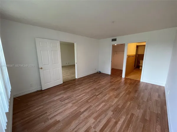 an empty room with wooden floor and closet