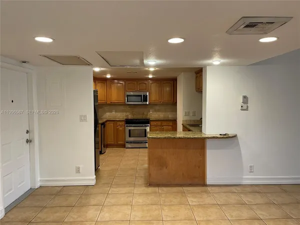 a view of kitchen with refrigerator and microwave