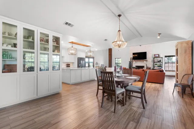 an empty room with wooden floor cabinet and windows