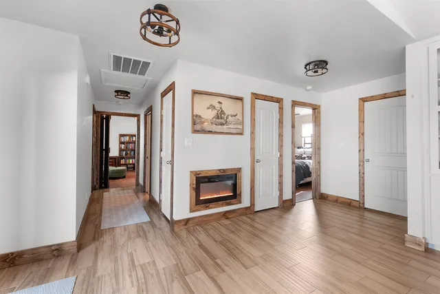 a bedroom with a bed a dresser and book shelfs