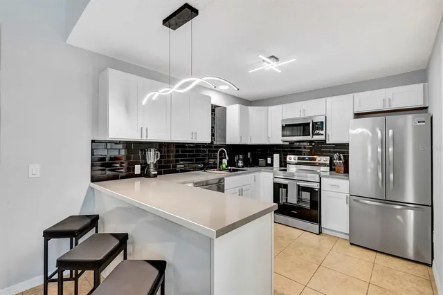 a kitchen with kitchen island a counter space appliances and cabinets