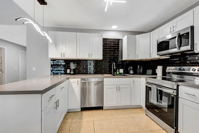 a kitchen with stainless steel appliances granite countertop a sink and a stove
