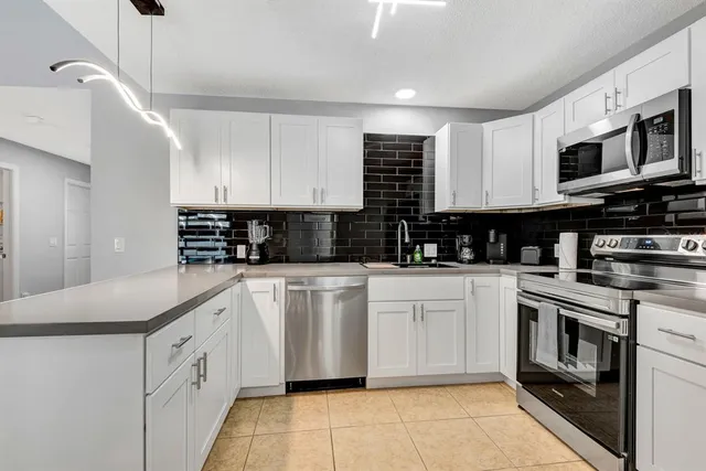 a kitchen with stainless steel appliances granite countertop a sink and a stove