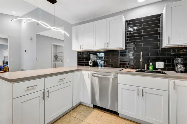 a kitchen with white cabinets sink and white appliances