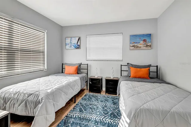 a bedroom with a bed and dresser next to a window