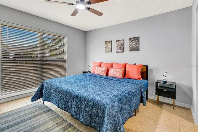 a bedroom with a bed and dresser with wooden floor