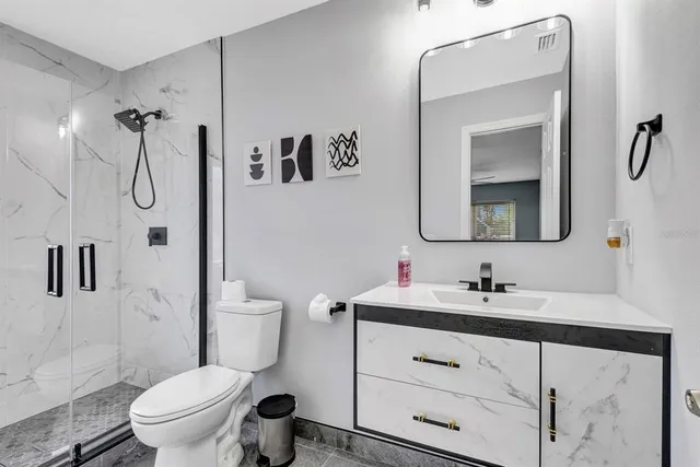 a bathroom with a sink vanity mirror and toilet