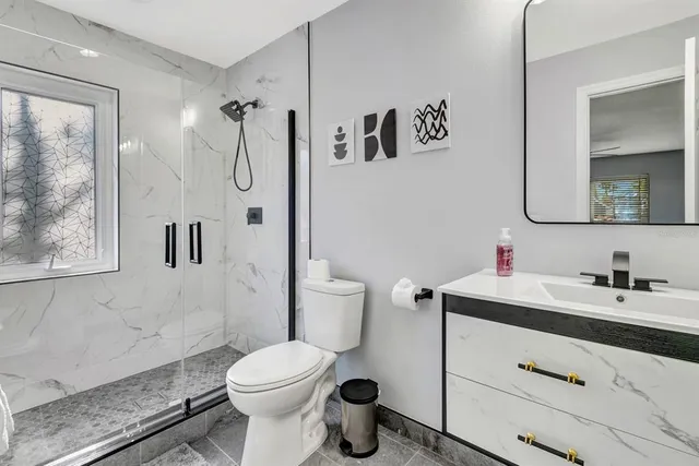 a bathroom with a sink a toilet and shower