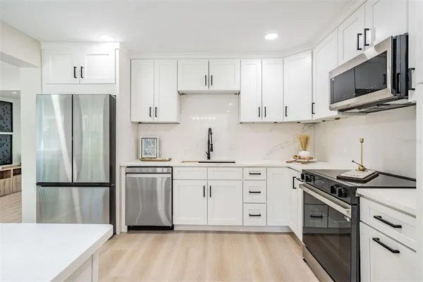 a kitchen with cabinets stainless steel appliances and a counter space