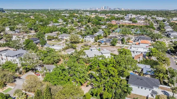 an aerial view of residential houses with outdoor space and trees