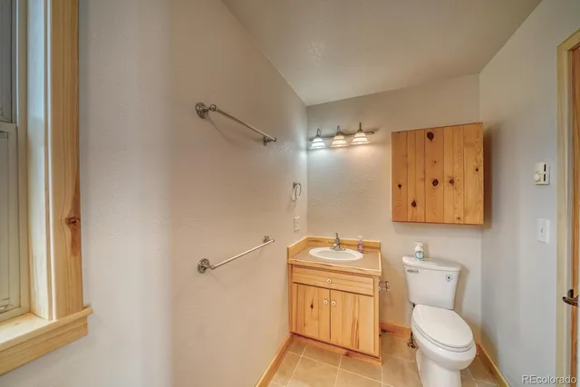a bathroom with a toilet a sink and mirror