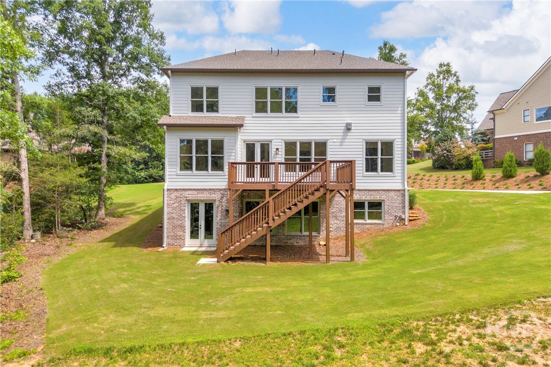 2476 St Martin Way Monroe, GA 30656 - Photo 73 of 75 Rear exterior featuring white horizontal siding, a multi-level wood deck, and a walk-out lower level with brick accents