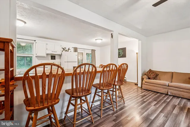 a view of a dining room with furniture a rug and wooden floor