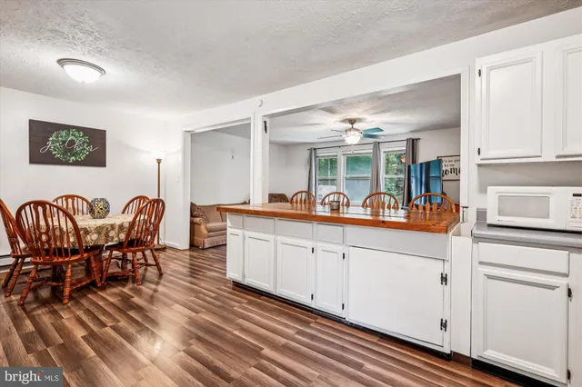 a large living room with stainless steel appliances granite countertop furniture and a wooden floors