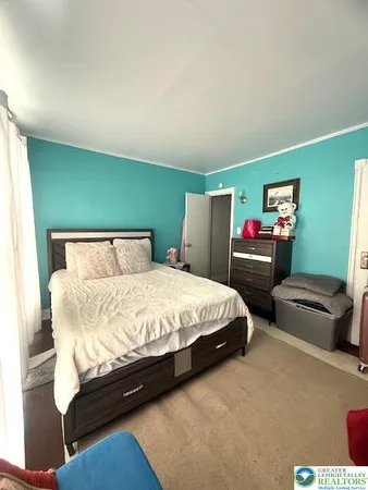 a spacious bedroom with two beds and painting on the wall