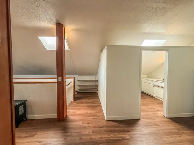 a view of a room with wooden floor
