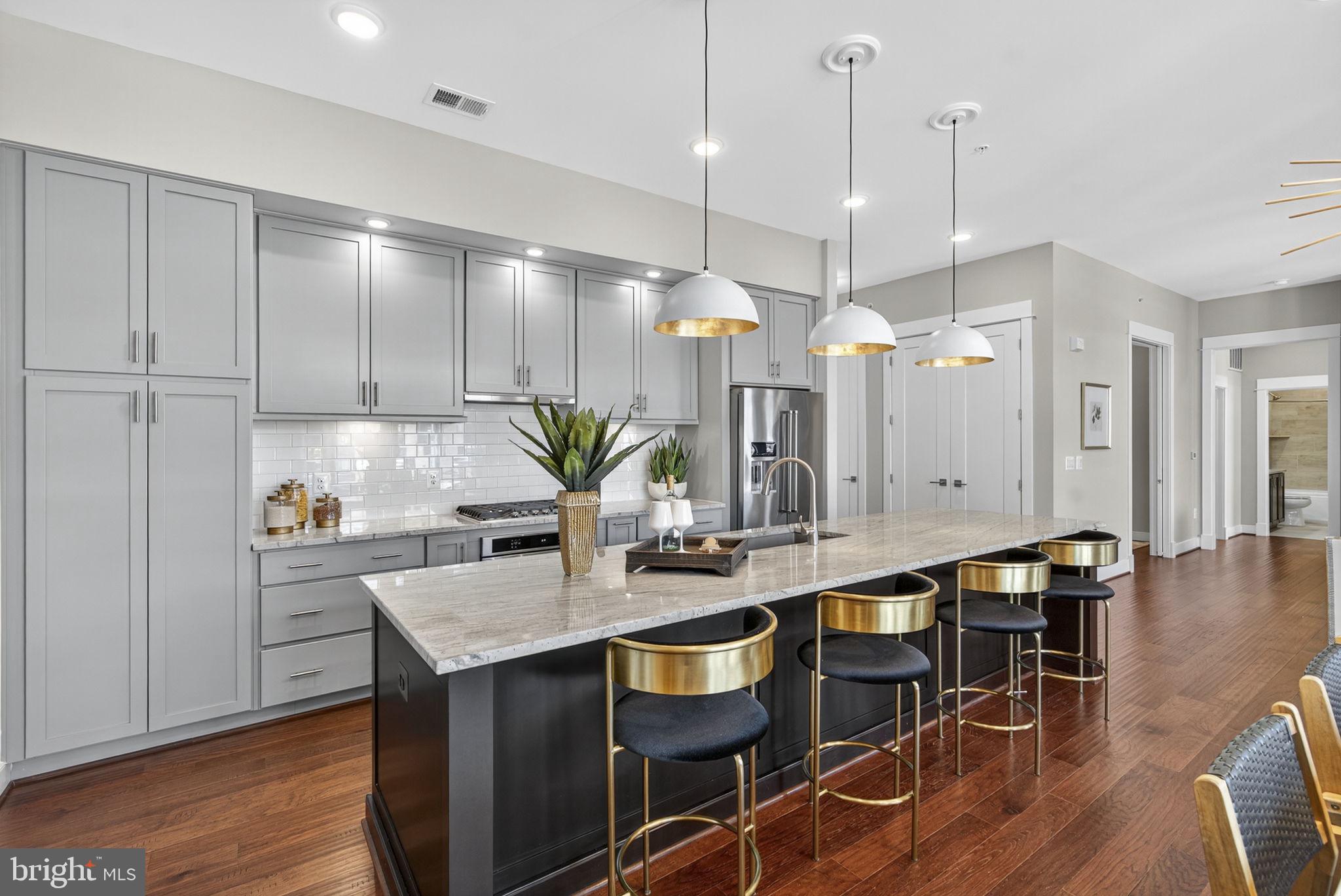 3 Stationmaster Street Southeast, Unit 402 Leesburg, VA 20175 - Photo 9 of 46 a kitchen with granite countertop a table chairs stove and white cabinets