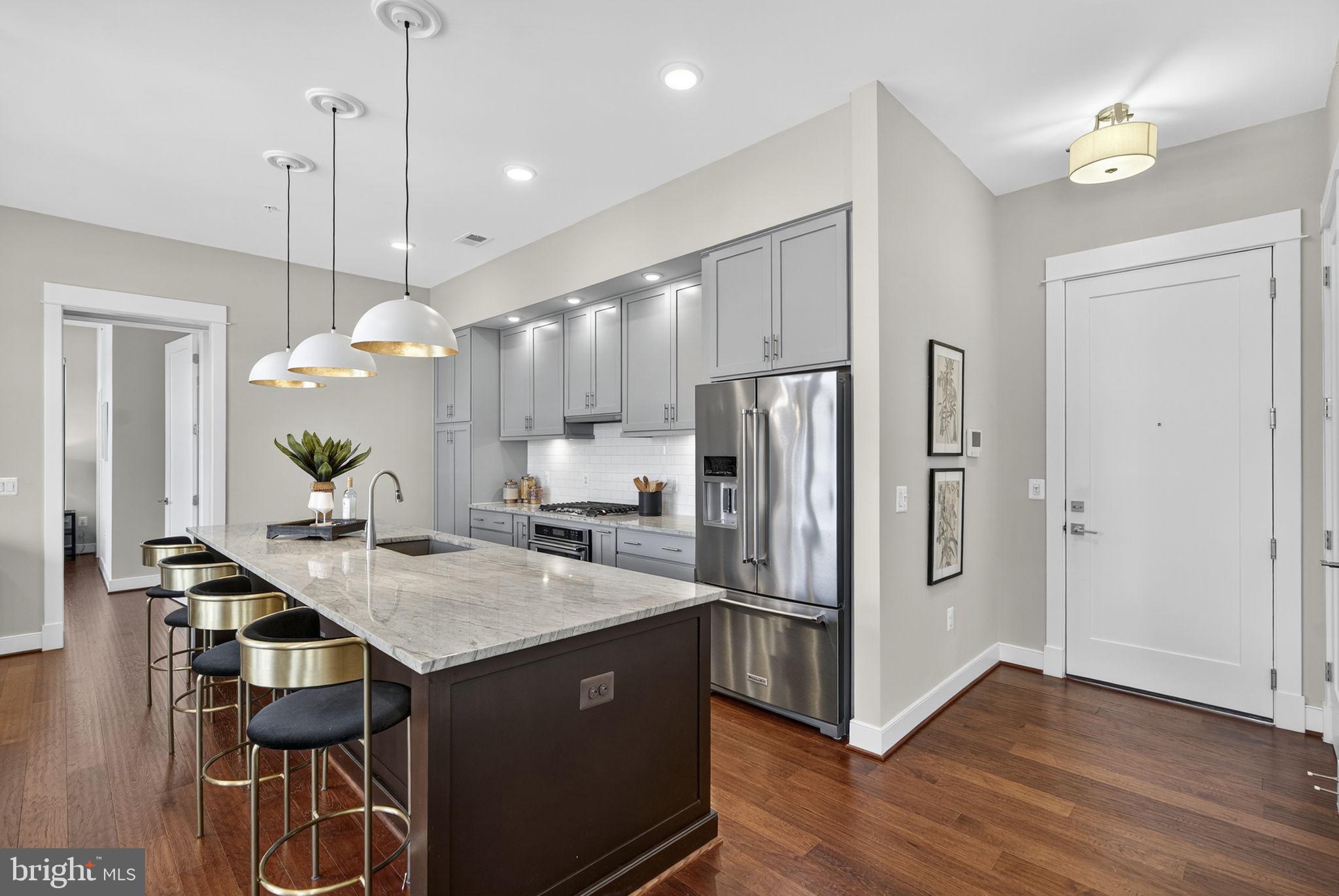 3 Stationmaster Street Southeast, Unit 402 Leesburg, VA 20175 - Photo 10 of 46 a kitchen with kitchen island a counter top space appliances and cabinets
