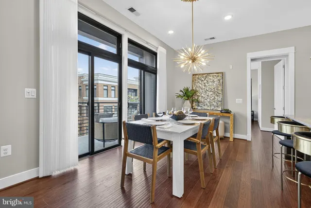 a kitchen with granite countertop a table chairs stove and white cabinets