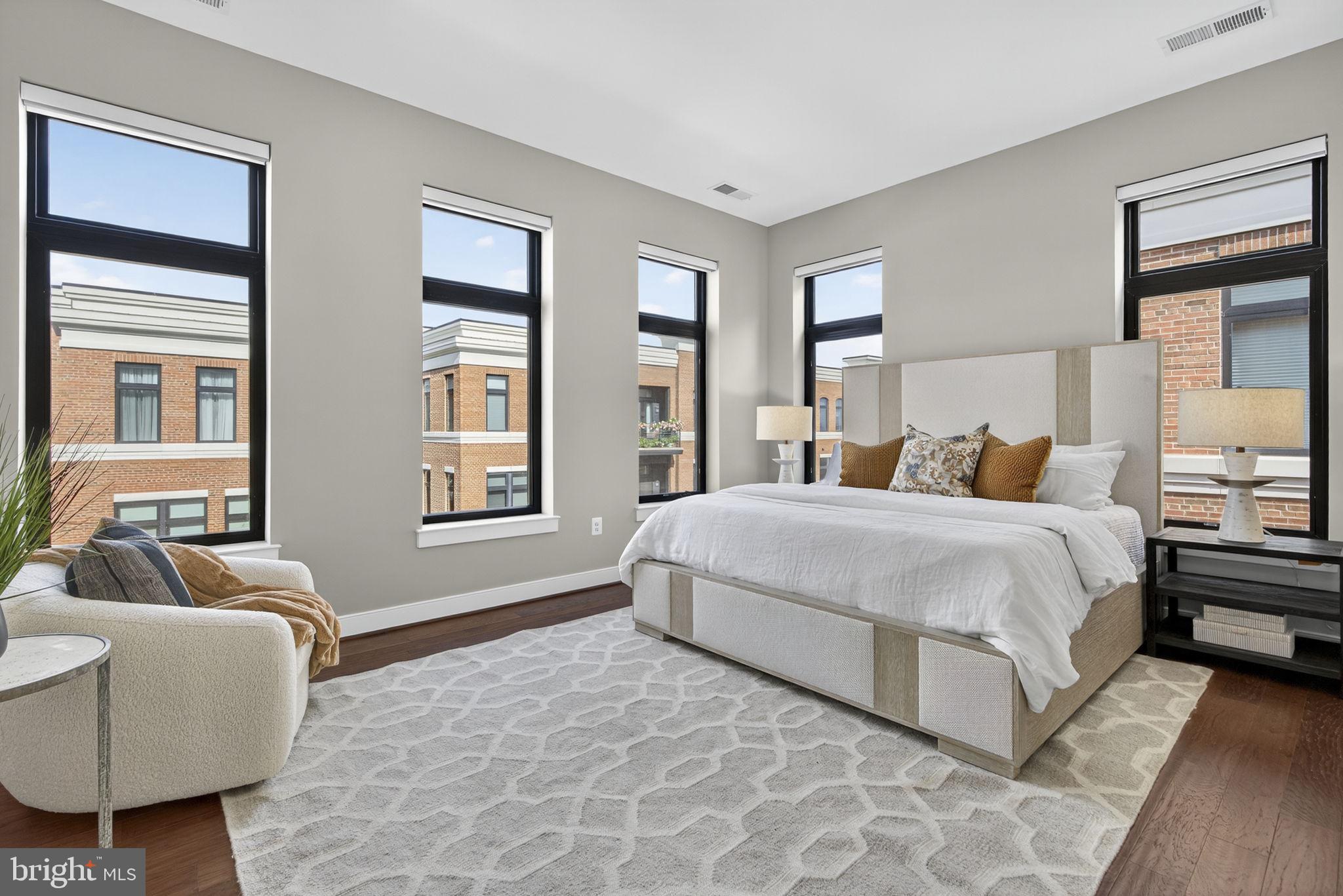 3 Stationmaster Street Southeast, Unit 402 Leesburg, VA 20175 - Photo 12 of 46 a bedroom with a large bed couch and windows