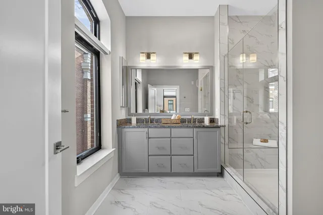 a bedroom with a large bed couch and windows