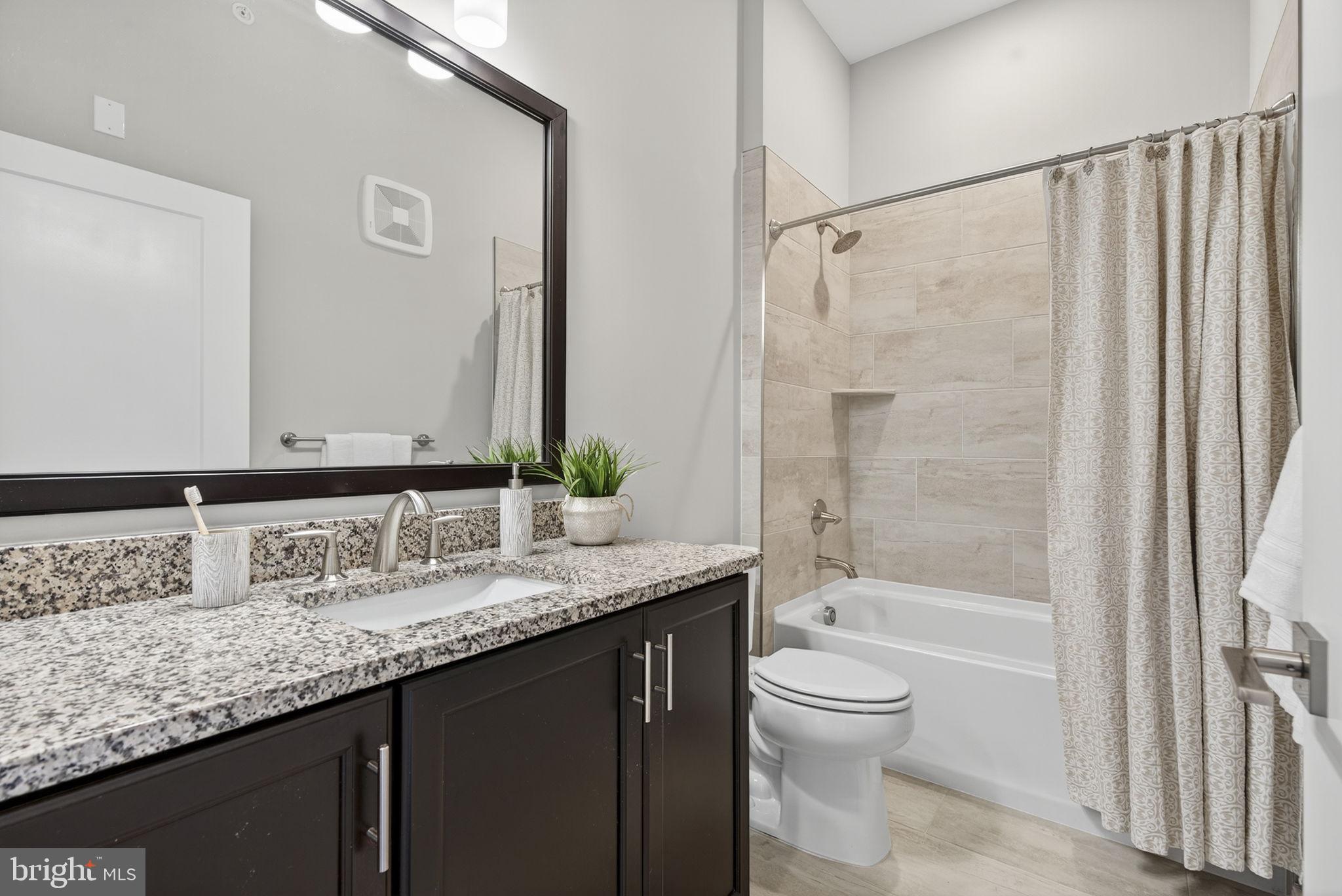 3 Stationmaster Street Southeast, Unit 402 Leesburg, VA 20175 - Photo 24 of 46 a bathroom with a granite countertop sink toilet and shower