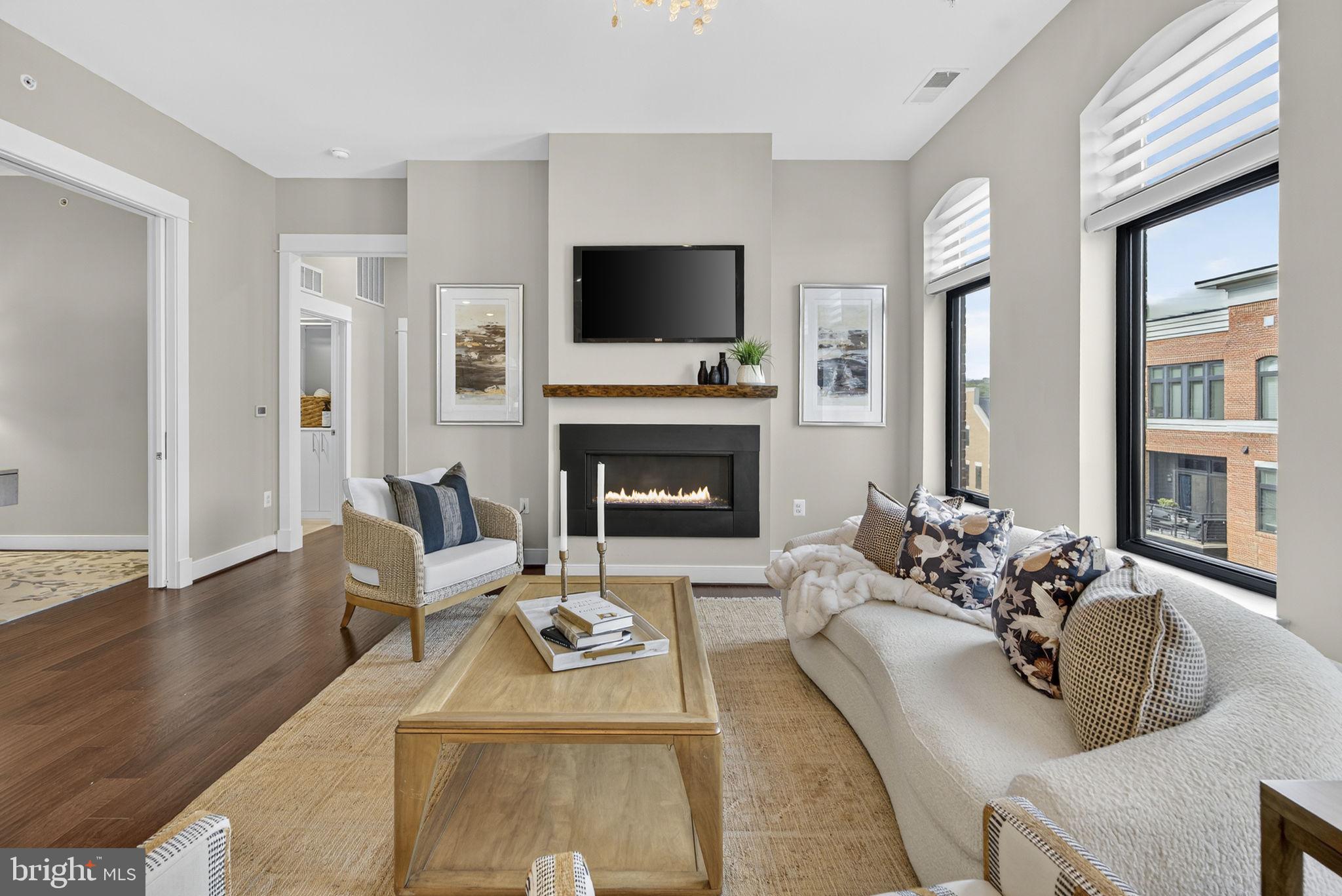 3 Stationmaster Street Southeast, Unit 402 Leesburg, VA 20175 - Photo 4 of 46 a living room with furniture flat screen tv and a fireplace