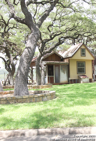 955 Faurie Road, Unit TINY HOUSE Lakehills, TX 78063 - Photo 3 of 23 a white house that has a tree in front of it