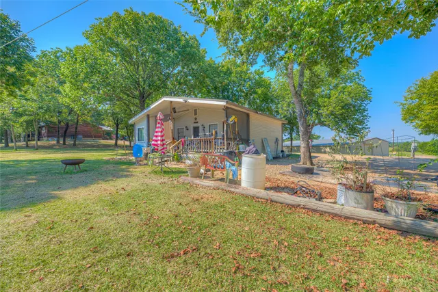 a view of a house with backyard and a tree