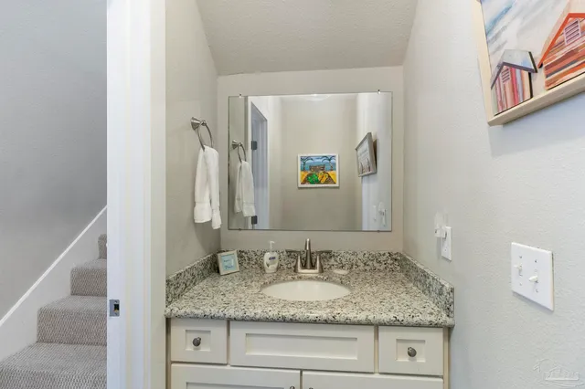 a bathroom with a granite countertop sink and a mirror