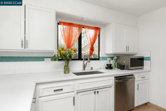 a kitchen with appliances a sink and a window