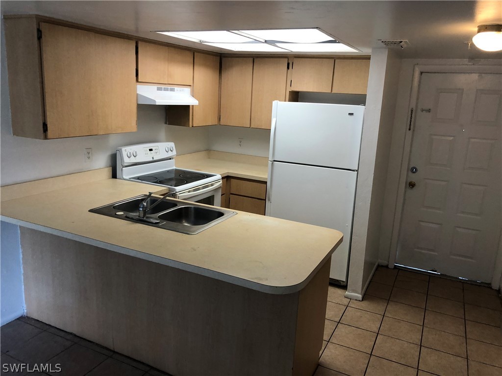 824 Alderman Street, Unit 209 Fort Myers, FL 33916 - Photo 2 of 7 a kitchen with a sink a stove and refrigerator